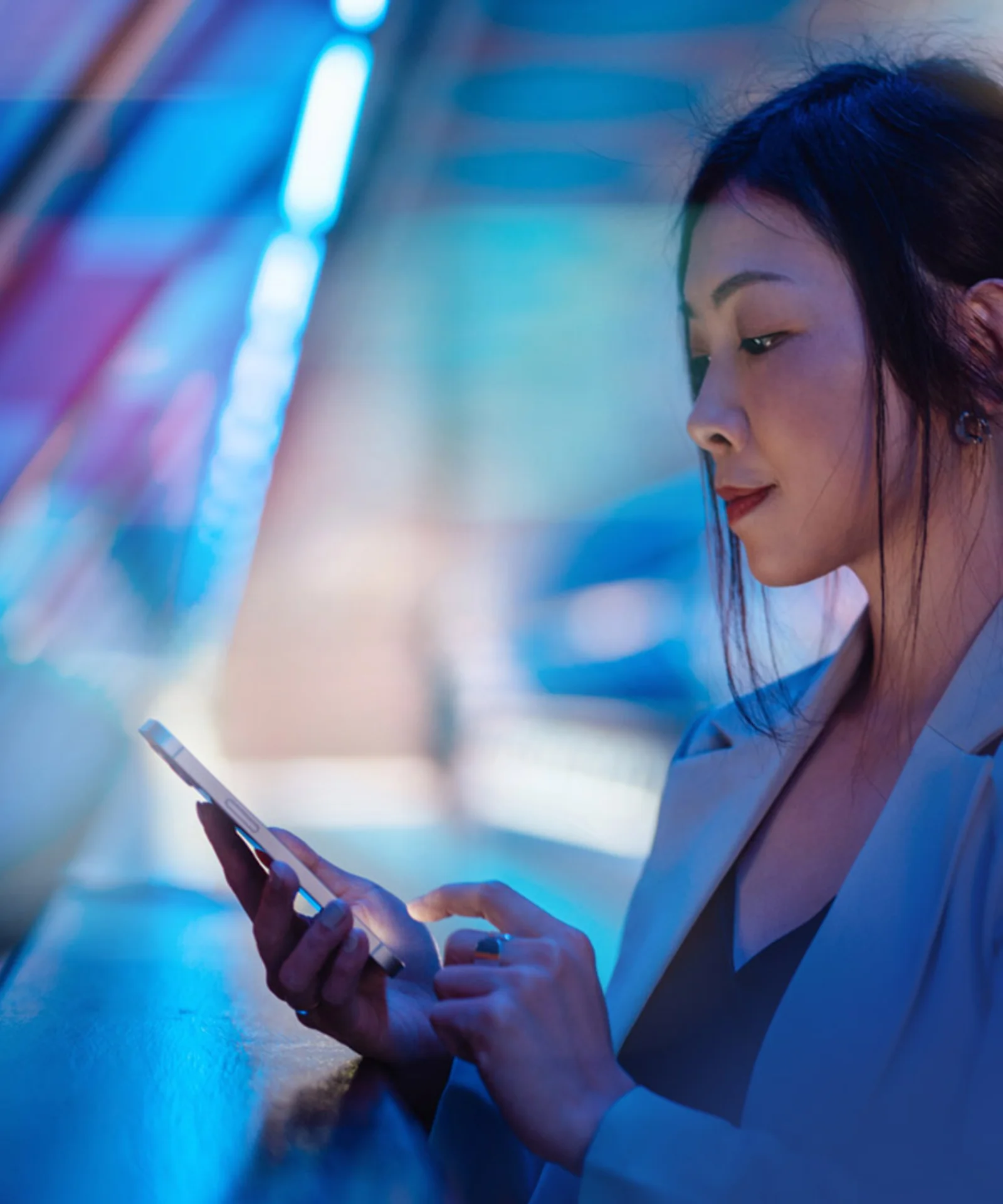 Seamless Digital Banking Experience A professional woman using a smartphone, symbolizing the streamlined digital banking solutions offered by GFT.