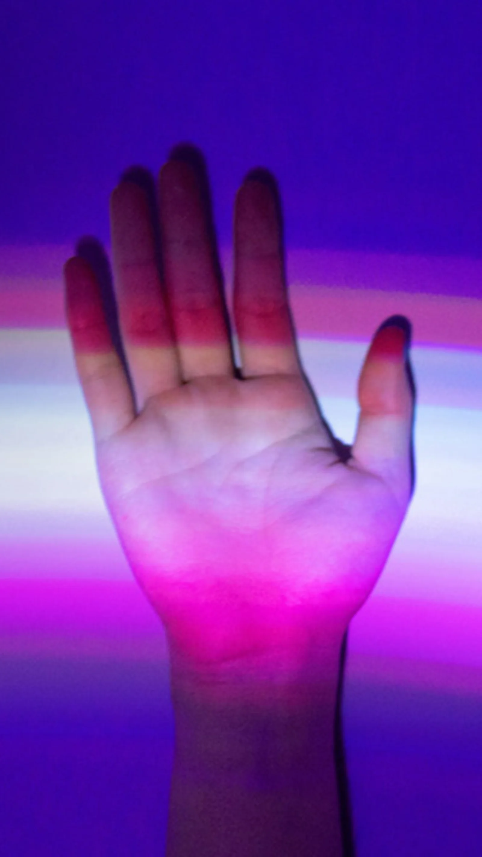 5 reasons to use GFT to implement FedNow Hand raised against a background of colorful light streaks, symbolizing the connection between human interaction and digital technology.