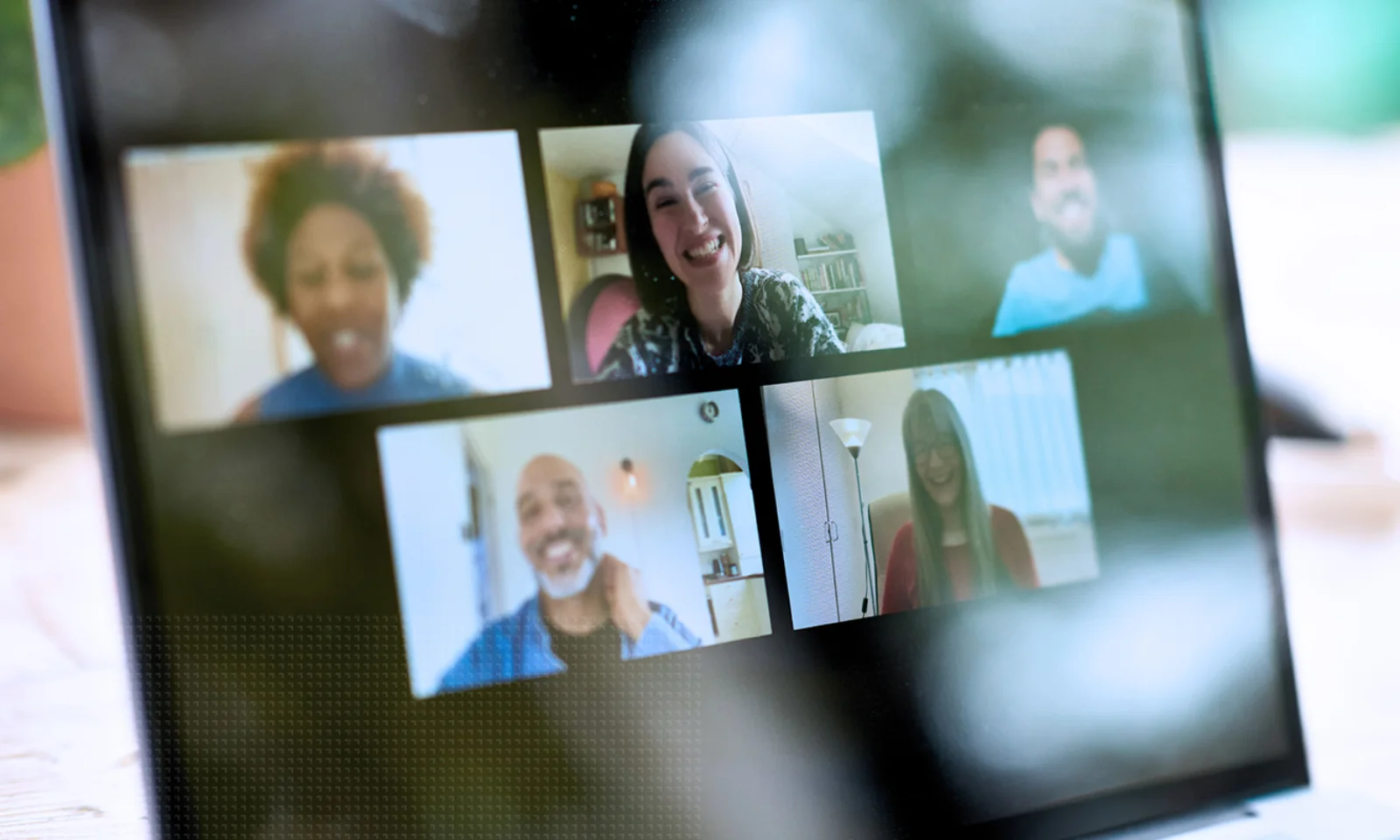 GFT Blog - AI as Thougth Partner - 02 Laptop screen showing five diverse team members in a virtual meeting on a video conferencing platform.